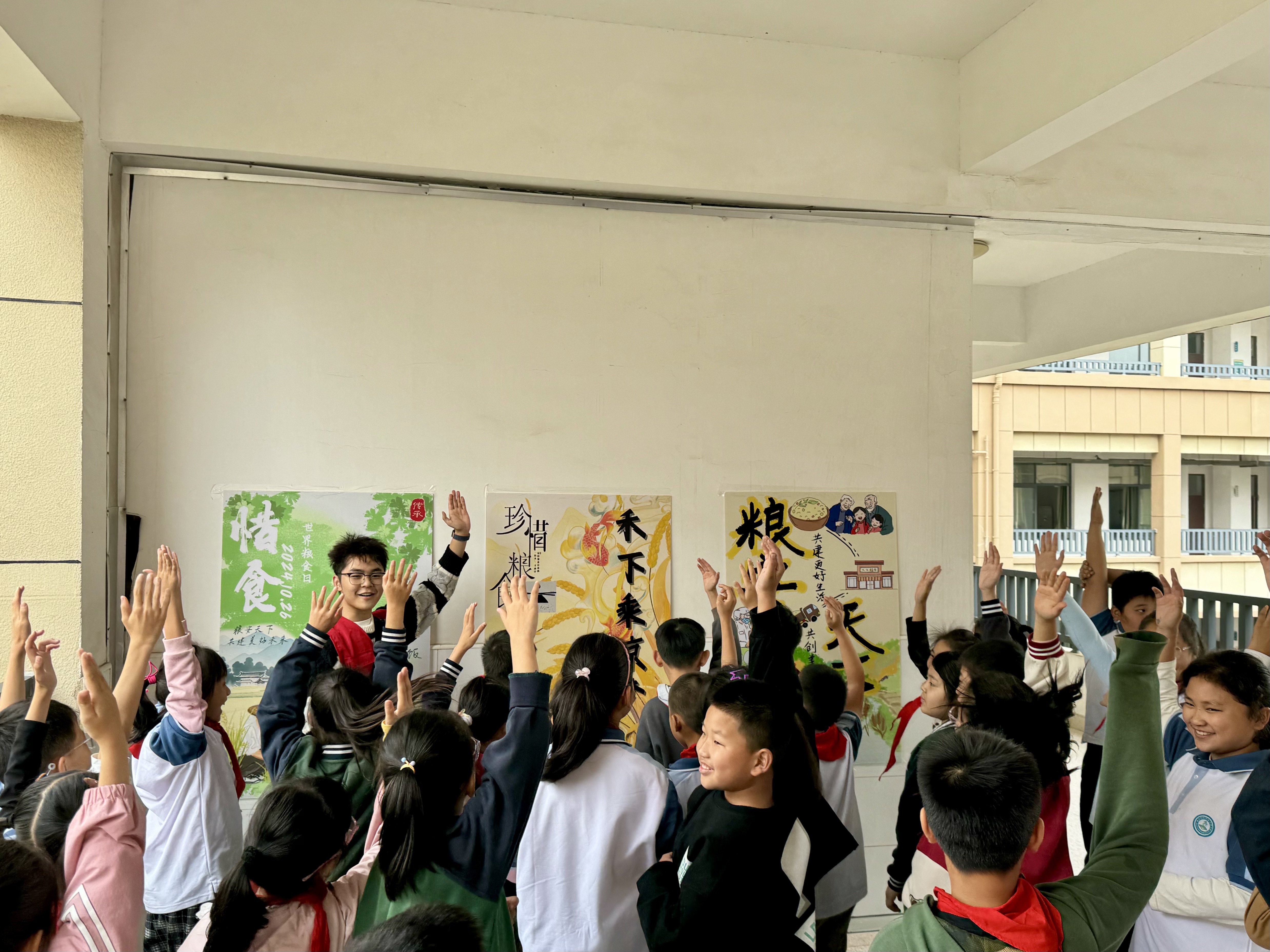 1729088351372864.jpg 图为志愿者在小学展示节粮减损海报优秀作品.jpg